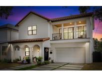 Stunning two-story home featuring a tile roof, balcony, arched entryway, and a well-manicured front yard at 2309 Depauw Ave, Orlando, FL 32804