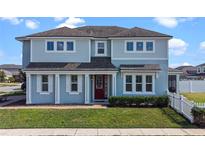 Charming two-story home with a well-maintained lawn, red door, and classic architectural details at 2464 Rapollo Dr, Kissimmee, FL 34741