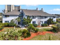 Exterior view of condo building, showcasing landscaping and nearby high-rise buildings at 4411 Sea Mist Ct # 174, New Smyrna Beach, FL 32169