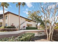 Tan building exterior with landscaping and parking area at 6102 Curry Ford Rd # 202, Orlando, FL 32822