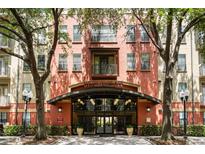 Inviting building entrance with manicured trees, covered entry, and UPTOWN PLACE signage at 911 N Orange Ave # 352, Orlando, FL 32801
