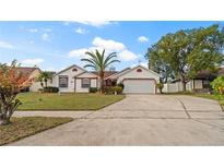 Charming single Gathering home featuring a well-manicured lawn, mature landscaping, and a two-car garage at 9664 Lake Douglas Pl, Orlando, FL 32817