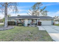 Charming single-story home with a well-maintained lawn, complemented by mature trees and tidy landscaping at 1428 Madrid Way, Winter Springs, FL 32708