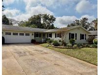 Ranch-style home with attached garage and mature landscaping at 3458 Balsam Dr, Winter Park, FL 32792