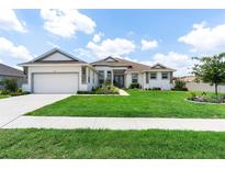 Charming single-story home featuring a well-manicured lawn and attached two-car garage at 530 Sanctuary Blvd, Winter Haven, FL 33881