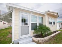 Charming home exterior featuring a well-manicured lawn and stone-lined garden at 662 Sinclair Cir, Tavares, FL 32778