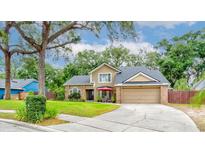 Inviting two-story home with a lush front yard, covered entryway, and attached two-car garage, under a shade tree at 848 Bucksaw Pl, Longwood, FL 32750
