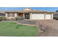 Inviting home featuring manicured lawn, mature landscaping, and a three-car garage at 9058 Sw 89Th Loop, Ocala, FL 34481