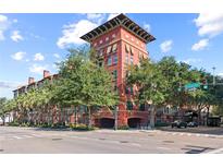 Upscale multi-story building with brick facade and lush landscaping at 911 N Orange Ave # 448, Orlando, FL 32801