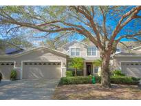 Two-story townhome with attached garage and lush landscaping at 980 Crestwood Commons Ave, Ocoee, FL 34761