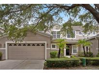 Charming home featuring a two-car garage, lush landscaping, and a welcoming entrance at 980 Crestwood Commons Ave, Ocoee, FL 34761