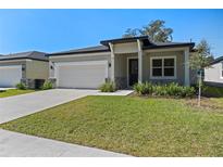 One-story home with a white garage door, landscaped lawn, and a covered entryway at 2896 Lingo Ln, Orlando, FL 32822