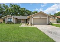 Charming single Gathering home with a well-manicured lawn, two-car garage and beautiful landscaping at 605 Marni Dr, Winter Springs, FL 32708