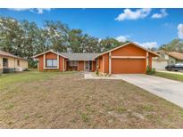 Charming single Gathering home featuring a well maintained lawn and attached two car garage with ample parking at 605 Marni Dr, Winter Springs, FL 32708