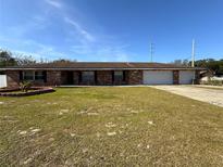 Brick ranch home with a large yard and attached garage at 1255 N Highland St, Mount Dora, FL 32757