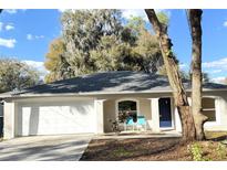 Charming single-story home with a well-manicured lawn, attached garage, and a cozy front porch seating area at 333 E Church St, Deland, FL 32724