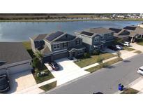 Aerial view of a two-story house with solar panels and a lake in the background at 4390 Bull St, St Cloud, FL 34772