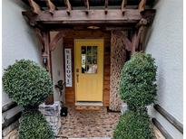 Inviting front entrance with a yellow door, stone accents, and lush landscaping at 124 Hollyhock Ct, Kissimmee, FL 34743