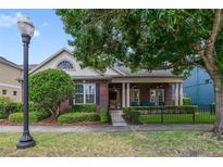 Charming red brick home featuring a cozy covered porch and manicured front yard at 3966 Avalon Park West Blvd, Orlando, FL 32828