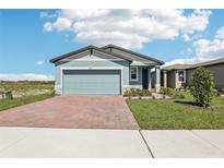 Charming single-story home with a two-car garage, a brick-paved driveway, and a beautifully manicured front yard at 4027 Copperleaf Ln, Poinciana, FL 34759