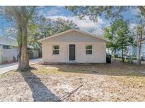 Quaint single-story home featuring neutral stucco, gray trim, and a compact front yard at 424 S Observatory Dr, Orlando, FL 32835
