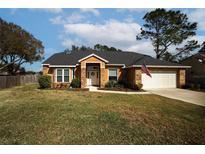 One-story house with a brick facade, a two-car garage, and a well-maintained lawn at 12826 Forestedge Cir, Orlando, FL 32828