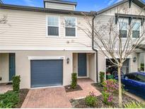 Townhouse exterior with gray garage door and brick walkway at 1578 Grand Rue Dr, Casselberry, FL 32707