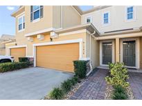 Charming two-story home with a well-manicured lawn and an attached two-car garage at 17438 Promenade Dr, Clermont, FL 34711