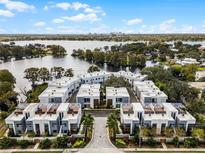 Stunning aerial view of modern townhomes overlooking a scenic lake with city skyline in the background at 1806 Mondrian Cir, Winter Park, FL 32789