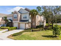 Charming townhome with a well-manicured lawn, lush shrubbery, and attached two-car garage at 2011 Stockton Dr, Sanford, FL 32771