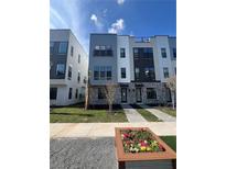 Modern townhouses with gray and white exterior, landscaping, and walkway at 2221 Valentine Aly, Orlando, FL 32804