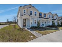 Charming two-story townhome with a covered front porch and landscaped front yard at 3100 Gardenia Reserve St, Apopka, FL 32712