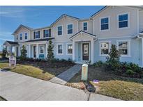 Charming two-story townhome with a walkway leading to a covered front porch and a well-manicured front yard at 3108 Gardenia Reserve St, Apopka, FL 32712