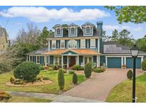 Charming two-story home with a copper roof, lush landscaping, and solar panels at 2438 River Rise Ct, Orlando, FL 32828