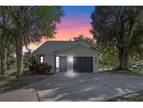 Charming house exterior with a dark gray door and garage at 254 Lake Thomas Dr, Winter Haven, FL 33880