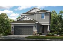Two-story house with gray siding, dark gray garage door, and stone accents at 5702 Gingham Dr, Kissimmee, FL 34758