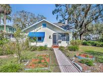 Charming bungalow with brick pathway leading to the front door and featuring awnings at 817 Greenwood St, Orlando, FL 32801