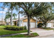 Charming single-story home featuring a two-car garage, brick driveway, and mature landscaping at 11753 Fan Tail Ln, Orlando, FL 32827