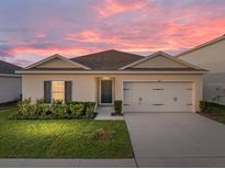 Charming single-story home featuring a well-manicured lawn and an attached two-car garage at 1207 Tank Trl, Haines City, FL 33844