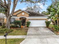 Charming single-story home featuring a well-maintained lawn and a two-car garage at 13713 Meadowpark Ave, Orlando, FL 32826