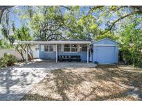 Charming single-story home with covered patio, brick driveway, and mature trees offering plenty of shade at 1412 Nebraska St, Orlando, FL 32803