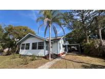 White house with a palm tree and landscaped yard at 214 N New Hampshire Ave, Tavares, FL 32778