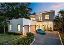 Stunning modern two-story home with a gravel driveway, two-car garage, and manicured landscaping at 2412 Chantilly Ave, Winter Park, FL 32789