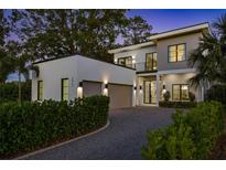 Stunning two-story modern home with a two-car garage, gravel driveway, and manicured landscaping at 2412 Chantilly Ave, Winter Park, FL 32789
