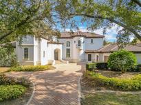 Two-story house with stucco exterior, tile roof, and a brick driveway at 5067 Latrobe Dr, Windermere, FL 34786