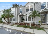 Charming townhome featuring lush landscaping, palm trees, and a welcoming front entrance at 564 Shadow Glenn Pl, Winter Springs, FL 32708