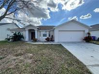 House exterior with two-car garage and landscaping at 594 Terranova Cir, Winter Haven, FL 33884