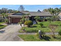 Charming single-story home featuring a well-manicured lawn and mature landscaping with palm trees at 616 Mellowood Ave, Orlando, FL 32825