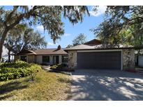 House exterior featuring stone accents and a large driveway at 8546 Amber Oak Dr, Orlando, FL 32817