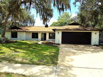 Charming single-story home with a well-manicured lawn and mature trees providing ample shade at 8546 Amber Oak Dr, Orlando, FL 32817